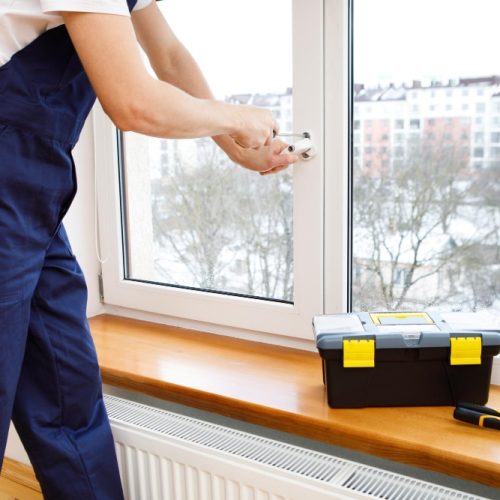 worker-installing-checking-window-house